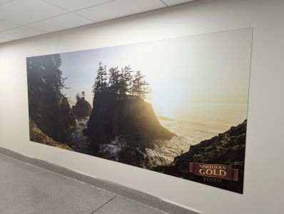 a scenic Oregon coast landscape with the sun setting over the ocean has been Vertically Printed on the wall at Northern Gold factory in Eugene, OR