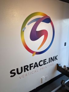 A company corporate logo has been printed on the wall with vibrant colors and text